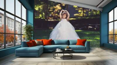 Outdoor portrait of adorable smiling little girl in white dress Wall mural