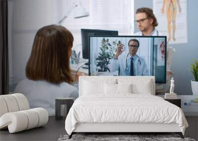 Rear of female doctor speaking on video call online consulting with African American young male specialist on computer, online consultation with physician on webcam conference about treatment, vaccine Wall mural