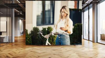 stylish hipster girl with bike using a phone and Sending Text Me Wall mural