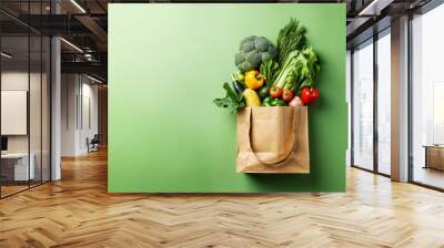 Purchases or delivery of healthy food. Healthy vegan vegetarian food in a paper bag, fruits and vegetables on a green, copy space. Food supermarket and the concept of pure vegan nutrition. Wall mural