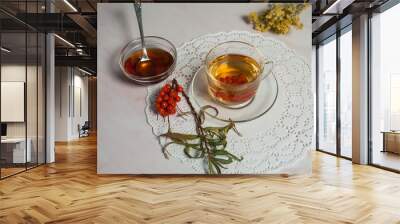 Vitamin tea with sea buckthorn. A bunch of dried tansy, dark honey, a sprig of sea buckthorn on a light pink marble background. Wall mural