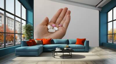 Girl holding pills in her hands, close-up. Treatment of colds during the disease season, healthy lifestyle Wall mural