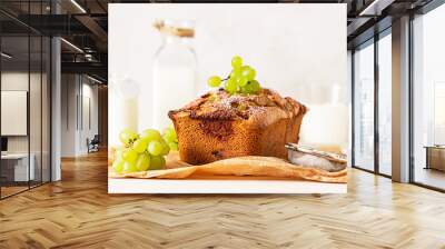 Delicious homemade grape loaf cake with thyme and sugar powder on parchment paper. Light stone background. Wall mural