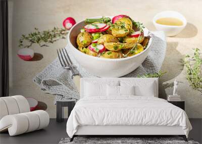 Homemade potato salad with green beans, fresh radishes and herbs dressing with olive oil and mustard sauce, light concrete background. Bright sunlight and trendy shadows. Wall mural