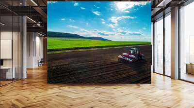 Aerial view of tractors working on the harvest field Wall mural