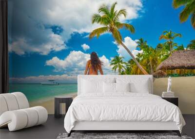 Carefree young woman relaxing on tropical beach Wall mural