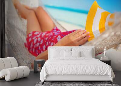 Young girl resting in a hammock under tall palm trees, tropical beach Wall mural