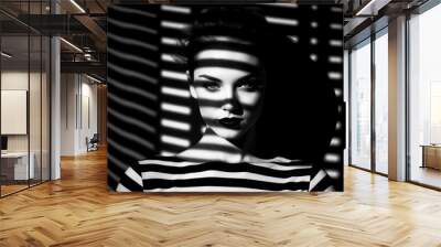 Black and white photo of woman's face with shadow on the wall. Wall mural