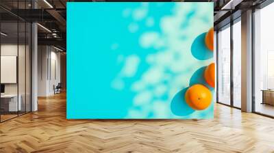 Three oranges floating on top of a blue pool Wall mural