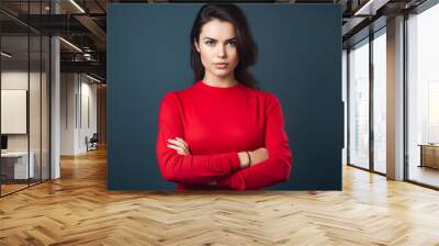 Woman in red top with her arms crossed. Wall mural