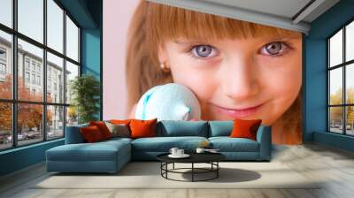 Beautiful little girl holding a blue sweet dessert macarons meringue in her hands portrait close-up, sweet pastries happy childhood childish emotions, selective focus	 Wall mural