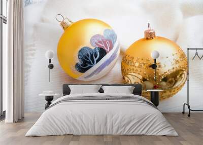 Gold Christmas toys on white knitted blankets. Golden painted balls newyear decor, selective focus Wall mural