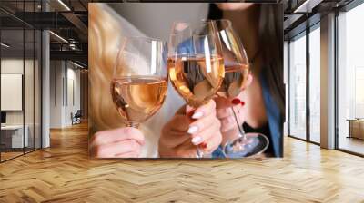 Girlfriends raise a toast with glasses of white colored wine.Close shot. Wall mural