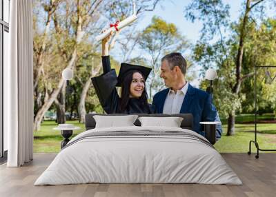 Happy caucasian graduated girl with her father on her graduation day.  Wall mural