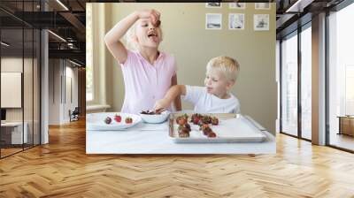 a little girl about to eat a chocolate strawberry she made Wall mural