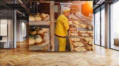 The bakers greases the buns with sunflower oil for further baking. Automated production of bakery products. Bread factory. Wall mural