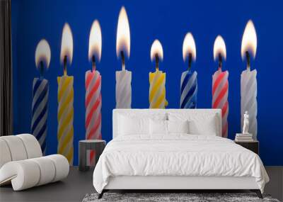 Burning birthday candles on blue background Wall mural