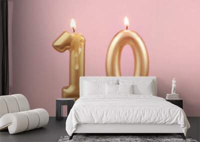 Burning golden birthday candles on pink background, number 10 Wall mural