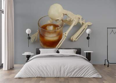 Skeleton or death with glass of alcohol on gray background.  Wall mural