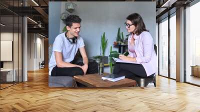 Boy teenager gives interview to woman psychologist in office Wall mural