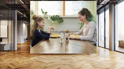 Children two girls eat lunch sitting at table in home kitchen, homemade food Wall mural