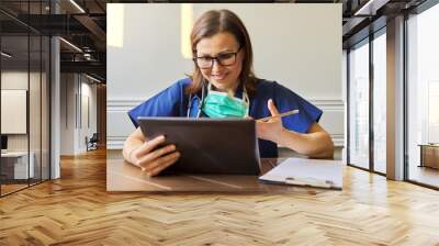 Female doctor counseling, helping patient online, medic using digital tablet for video call Wall mural