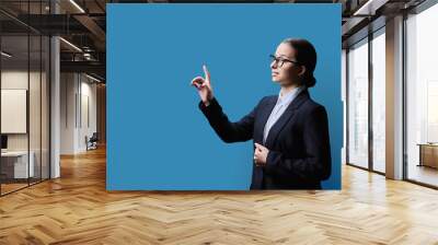 Female student touching on virtual screen, blue copy space background Wall mural