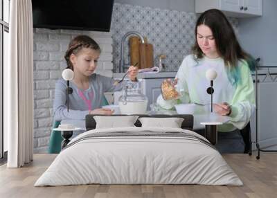 Girls having breakfast sitting at table in home kitchen Wall mural