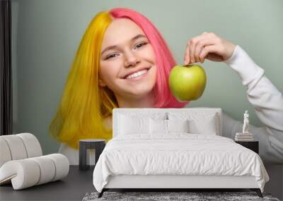 Head shot of beautiful smiling teenage girl with white smile with teeth, holding an apple Wall mural