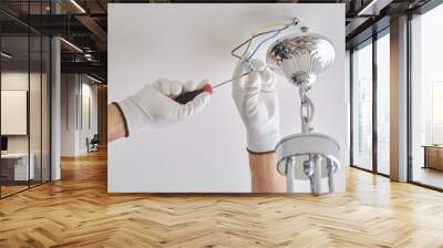 Installation ceiling lamp, hands of electrician fixing chandelier Wall mural