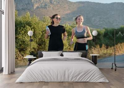 Middle-aged mother and teenage daughter running outdoor Wall mural