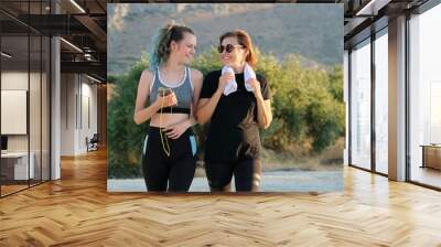 Outdoor portrait of mother and teenage daughter doing sports jogging Wall mural