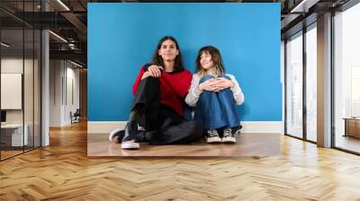 Portrait of a teenage couple of young students on a blue background. Wall mural