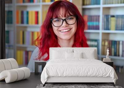 Portrait of female college student in glasses with laptop backpack, looking at camera Wall mural