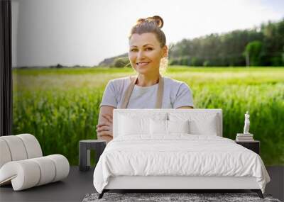 Portrait of mature smiling woman farmer in field Wall mural