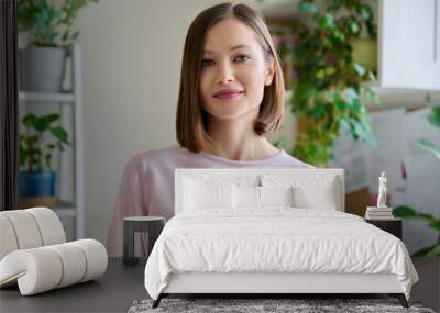 Portrait of young smiling woman in home interior Wall mural