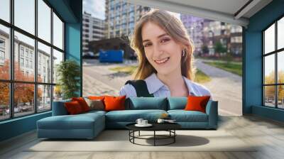 Selfie portrait of young happy blonde female looking at camera outdoor Wall mural