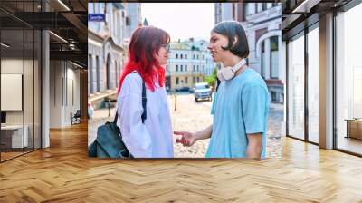 Teenage friends male and female talking on the street of city Wall mural