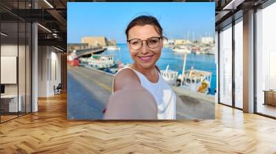 Woman taking photo against the backdrop of historic fortress, sea bay Wall mural