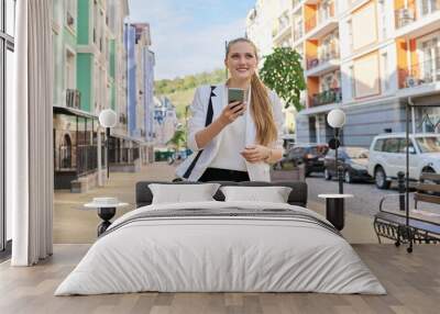 young beautiful woman using smartphone, business woman in white jacket Wall mural