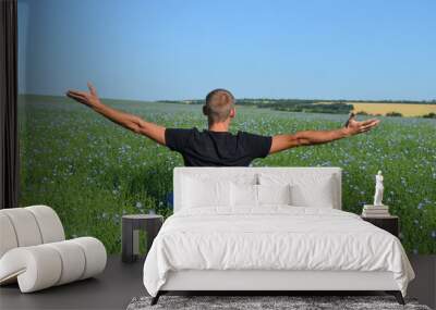 Man on the background of a green field. Wall mural