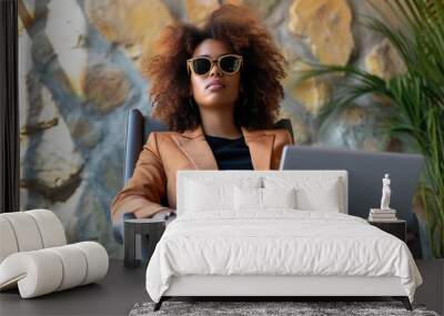 Businesslike African-American woman using laptop on tropical luxury hotel resort under palms beach. Freelance online remote work freedom concept. Business woman work on computer while travelling.  Wall mural