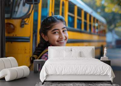 Portrait of cute happy smiling little Indian pupil teenage girl,  teenager student standing in front of school bus vehicle, Back to School education concept Wall mural