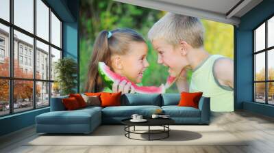 Young girl and boy eating watermelon Wall mural