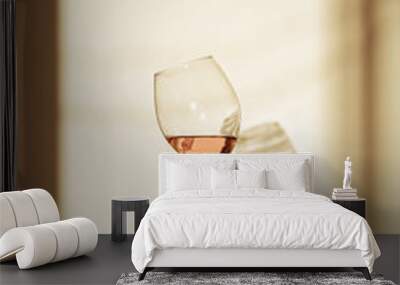 Glass of pink wine in hand with shadow on the wall Wall mural