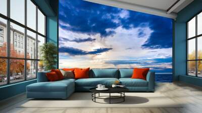 The blue beautiful landscape of the sky with graceful clouds blockaded the bright sun over the sea, the ship in the distance on the horizon. Beautiful colorful sunset on the Black Sea, Sochi, Russia. Wall mural