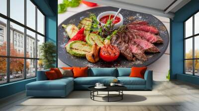 chopped medium rare steak with grilled vegetables. Sauce is served with the dish. Dish on a white plate in natural light. Wall mural