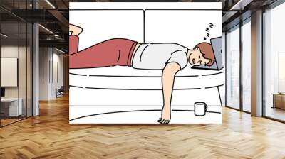 Tired man fall asleep on sofa with laptop Wall mural