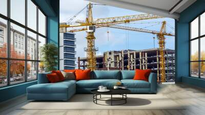 two yellow building cranes at work Wall mural