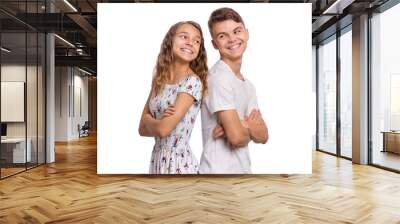 Portrait of smiling teen boy and girl standing back to back. Teenagers look at each other. Happy children in casual clothes with folded arms, isolated on white background. Friendship and love concept. Wall mural